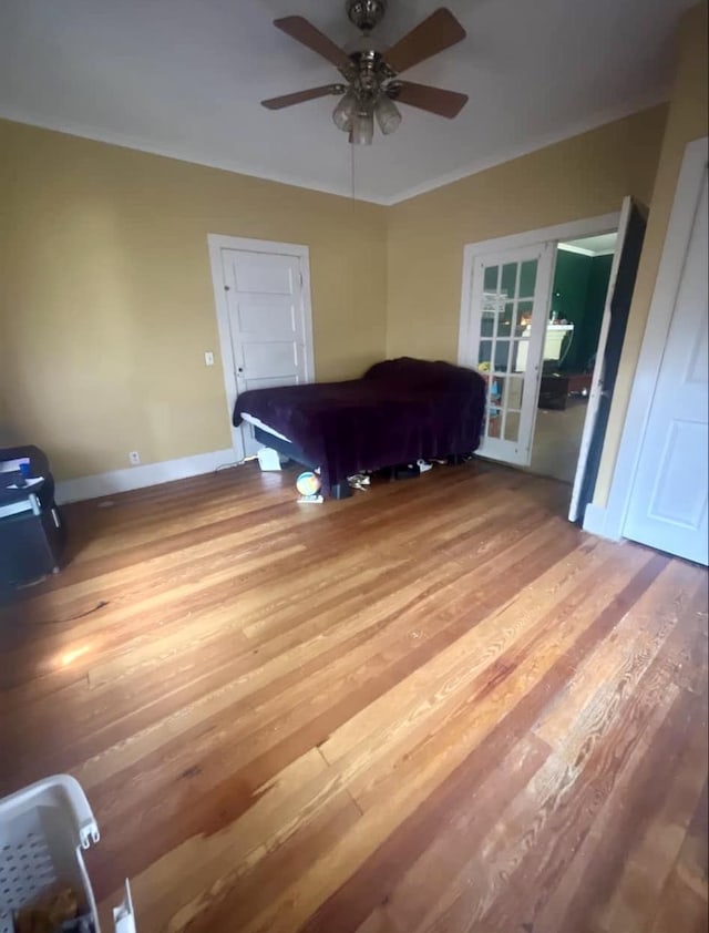 unfurnished bedroom featuring ceiling fan, french doors, pool table, and light hardwood / wood-style flooring