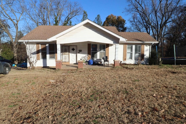 ranch-style house with a front lawn and a trampoline