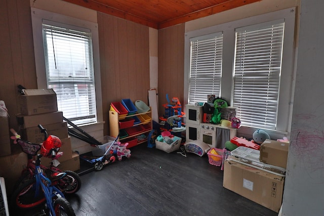 playroom featuring wood ceiling, wood walls, and dark wood-type flooring