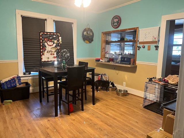 dining room with crown molding and light wood-type flooring