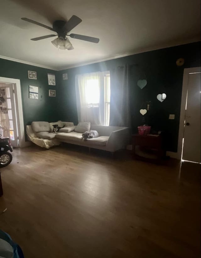 living area with hardwood / wood-style flooring, ceiling fan, and crown molding