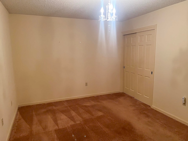 spare room with a textured ceiling and carpet floors