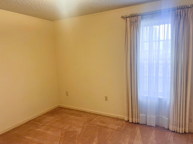 unfurnished room featuring carpet floors and a textured ceiling