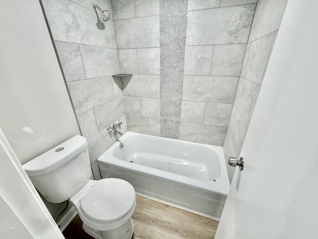 bathroom featuring hardwood / wood-style floors, tiled shower / bath combo, and toilet