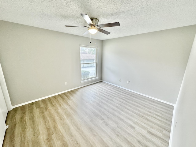 empty room with ceiling fan, light hardwood / wood-style flooring, and a textured ceiling