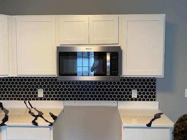 kitchen featuring white cabinets and decorative backsplash