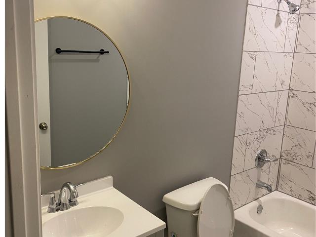 full bathroom with vanity, toilet, and tiled shower / bath