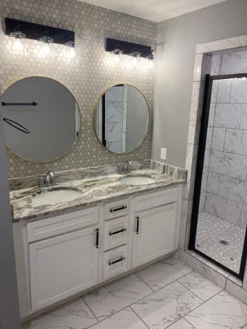 bathroom with vanity and a shower with door