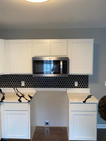 kitchen with white cabinetry and tasteful backsplash