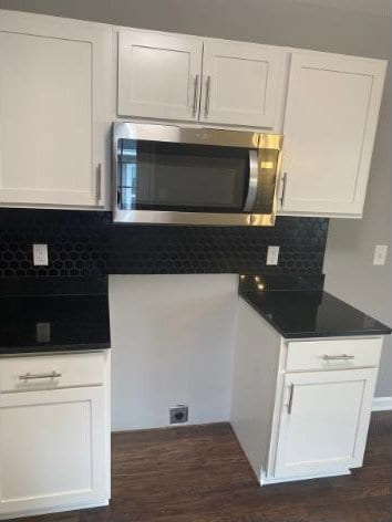 kitchen featuring dark hardwood / wood-style flooring, tasteful backsplash, and white cabinetry