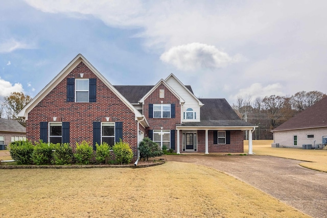 view of front of home with central AC and a front lawn