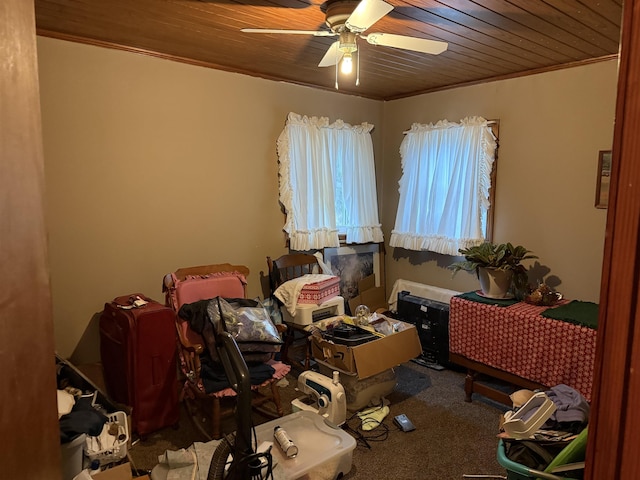 interior space featuring ornamental molding, ceiling fan, carpet, and wood ceiling