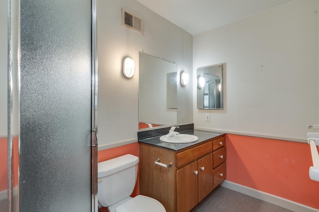 bathroom with tile patterned flooring, vanity, and toilet