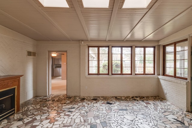 unfurnished sunroom featuring a skylight