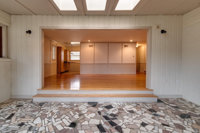 interior space with light hardwood / wood-style floors and wooden walls