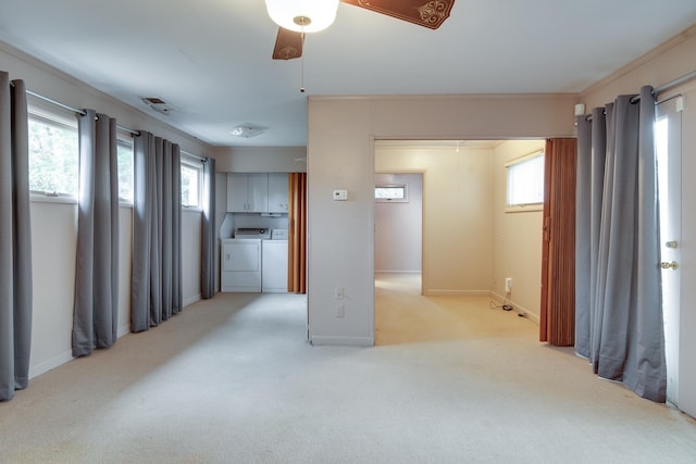 unfurnished room featuring light carpet, plenty of natural light, crown molding, and independent washer and dryer