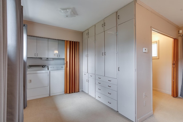 washroom featuring washer and clothes dryer, cabinets, crown molding, and light carpet