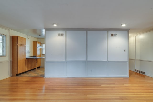 interior space with light hardwood / wood-style floors and crown molding