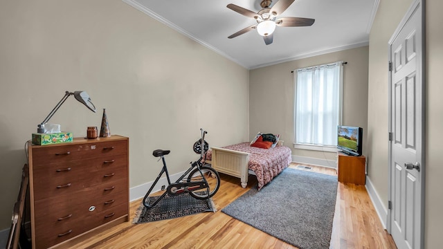 bedroom featuring hardwood / wood-style flooring, ceiling fan, and ornamental molding