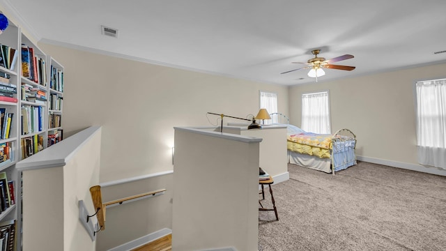 bedroom with ceiling fan, light colored carpet, and crown molding