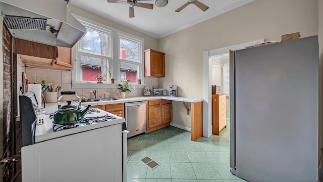 kitchen with ceiling fan, tasteful backsplash, range hood, appliances with stainless steel finishes, and ornamental molding