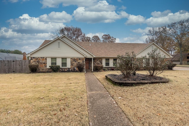 single story home featuring a front yard, fence, stone siding, and a shingled roof