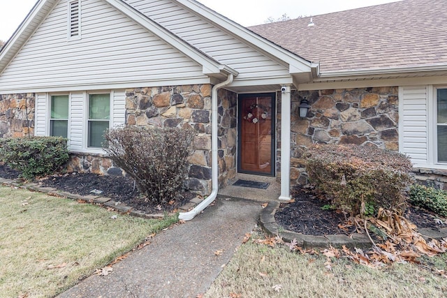 property entrance featuring stone siding and a shingled roof