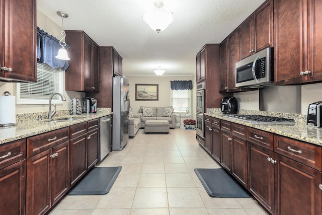 kitchen featuring hanging light fixtures, a healthy amount of sunlight, sink, and stainless steel appliances