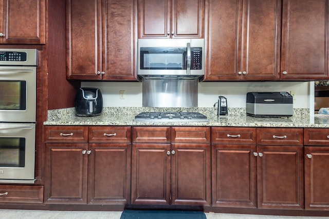 kitchen with light stone countertops and appliances with stainless steel finishes