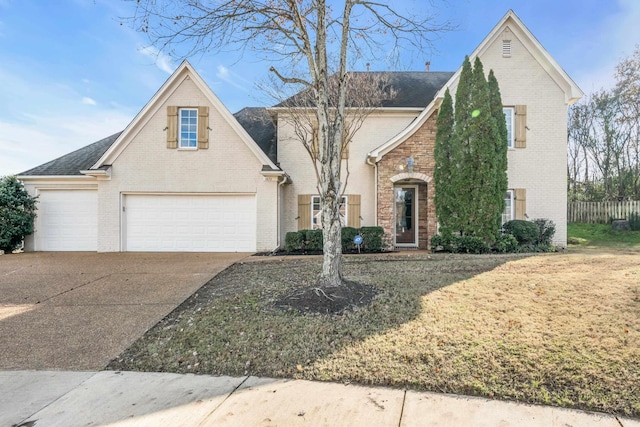 view of property featuring a garage and a front lawn