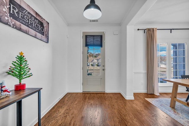 foyer entrance with hardwood / wood-style floors and crown molding