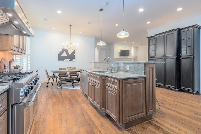 9207 Liggon Green Ln, Germantown, TN 38139 - kitchen with extractor fan, stainless steel appliances, light wood-style floors, decorative backsplash, and light stone countertops