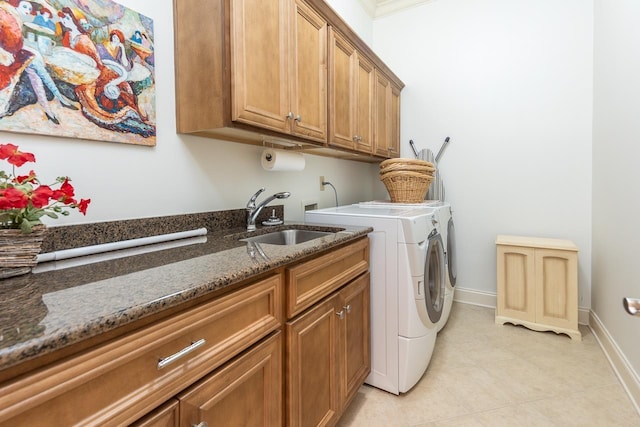 laundry room featuring light tile patterned flooring, cabinets, separate washer and dryer, and sink