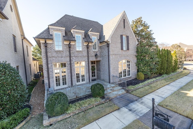9207 Liggon Green Ln, Germantown, TN 38139 - french country inspired facade with brick siding, roof with shingles, and french doors