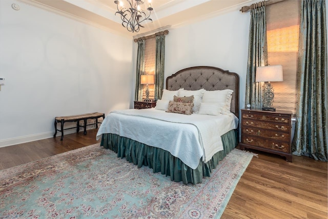 bedroom with wood-type flooring, ornamental molding, and a chandelier