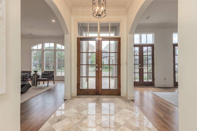 9207 Liggon Green Ln, Germantown, TN 38139 - foyer entrance featuring french doors, ornamental molding, a chandelier, light wood finished floors, and arched walkways