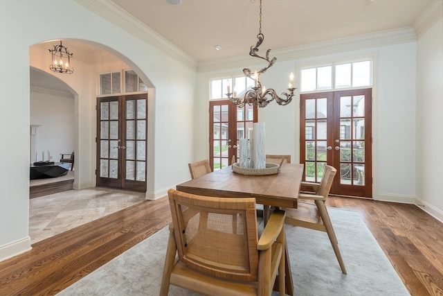 9207 Liggon Green Ln, Germantown, TN 38139 - dining room with french doors, arched walkways, a chandelier, crown molding, and wood finished floors