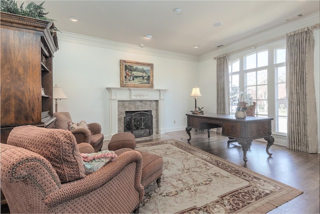 home office featuring a fireplace, wood-type flooring, and ornamental molding