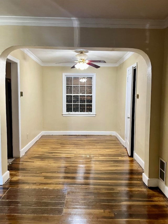 spare room with crown molding, ceiling fan, and dark wood-type flooring