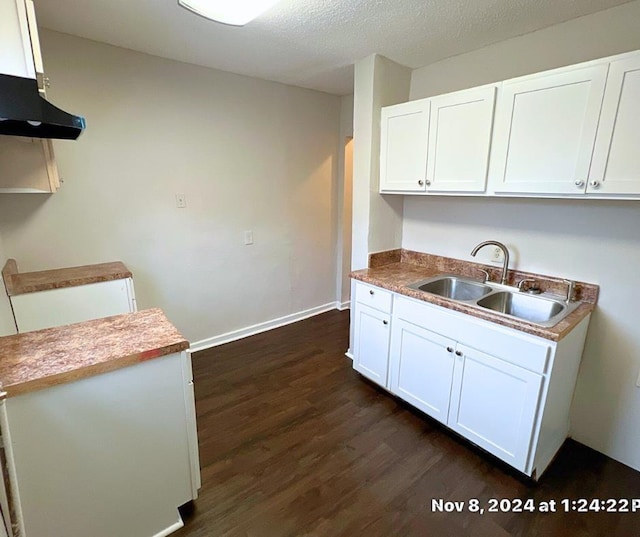 kitchen featuring sink, dark wood-type flooring, a textured ceiling, white cabinets, and exhaust hood