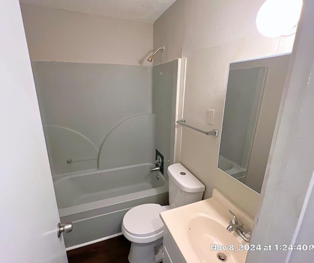 full bathroom featuring vanity, a textured ceiling, toilet, and shower / washtub combination