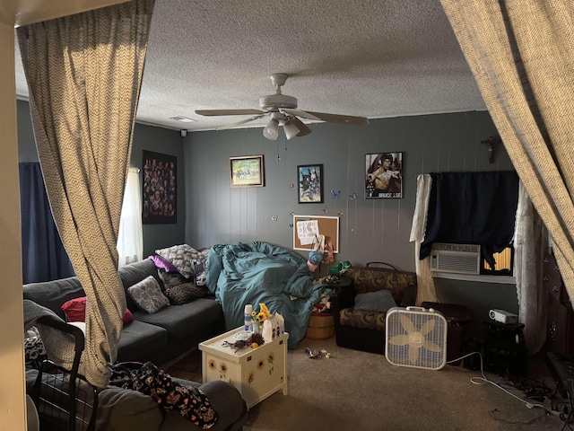 living room with ceiling fan, cooling unit, a textured ceiling, wooden walls, and carpet