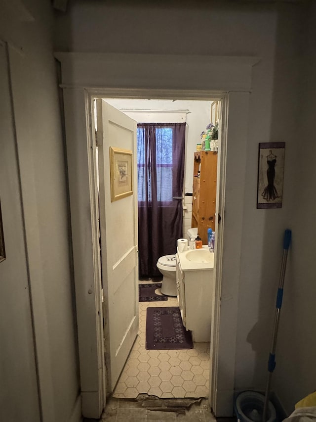 bathroom with tile patterned flooring, vanity, and toilet