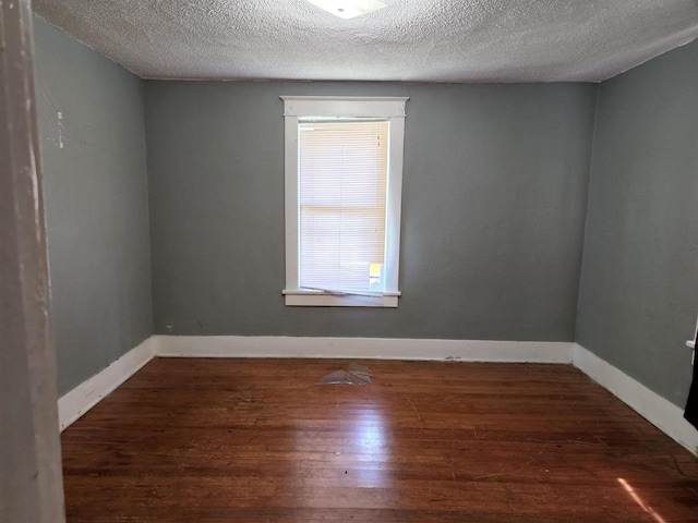 spare room with dark hardwood / wood-style flooring and a textured ceiling