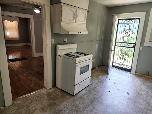 kitchen with white cabinets, light hardwood / wood-style flooring, white range with gas cooktop, and ceiling fan