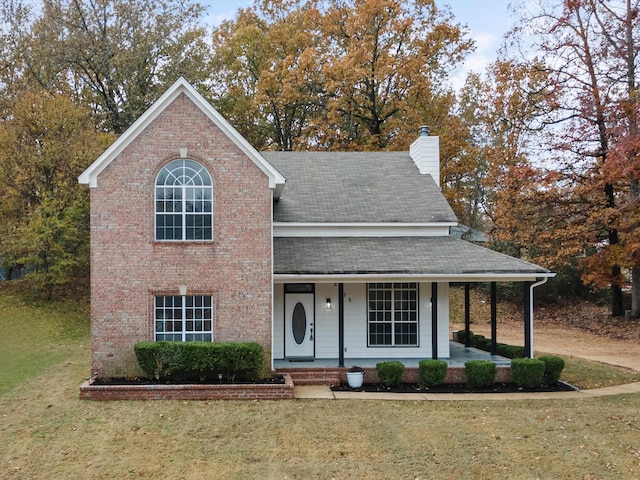 view of front of property featuring covered porch and a front yard