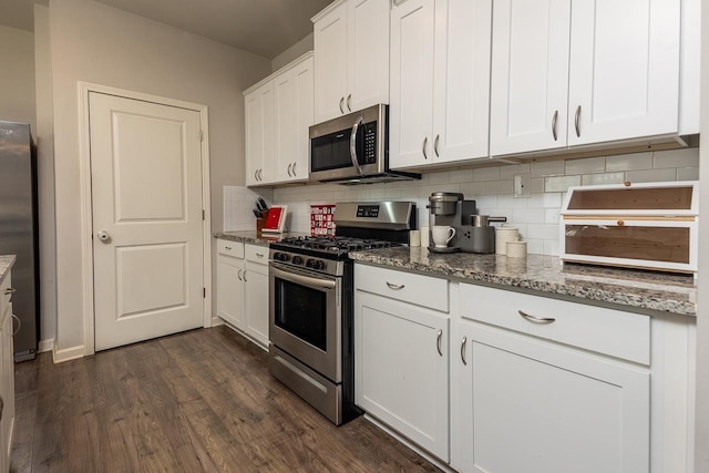 kitchen featuring white cabinets, appliances with stainless steel finishes, dark hardwood / wood-style flooring, and stone countertops