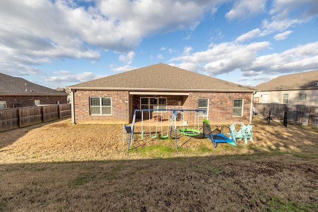 back of property with a playground