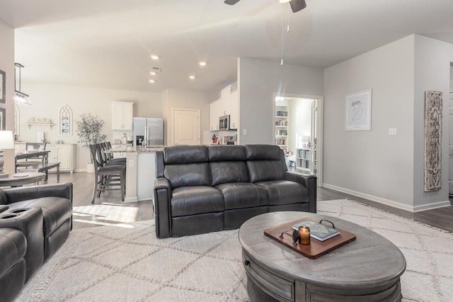 living room featuring light wood-type flooring and ceiling fan