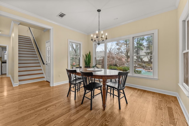 dining area with plenty of natural light, ornamental molding, and light hardwood / wood-style flooring